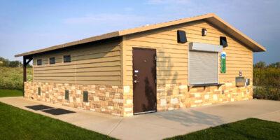 concession building with Horizontal lap upper walls, custom rock texture lower walls with cedar shake roof
