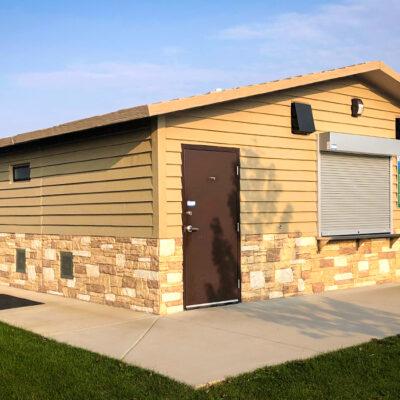 concession building with Horizontal lap upper walls, custom rock texture lower walls with cedar shake roof