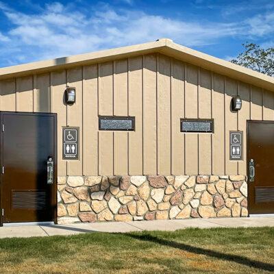 shower building with Board and batt walls with cedar shake roof and optional water fountain