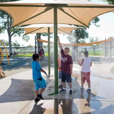 Kids getting misted under a misting shelter