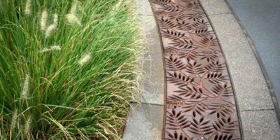 Decorative radius grate beside grass