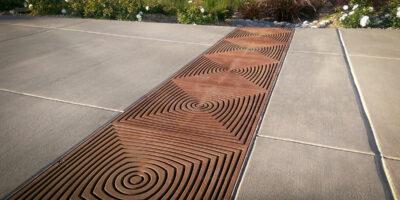 Decorative trench grate crossing a sidewalk