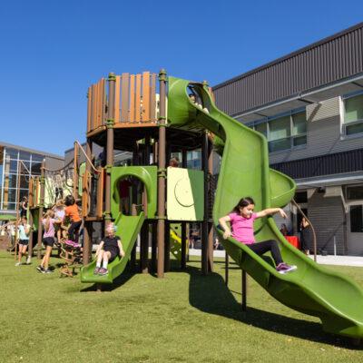 green, blue and brown playground with engineered wood fibre (EWF) and artificial grass surfacing
