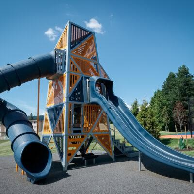 green, blue and orange playground on pour-in-place (PIP) surfacing