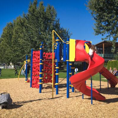 red, blue and yellow playground on engineered wood fibre surfacing (EWF)