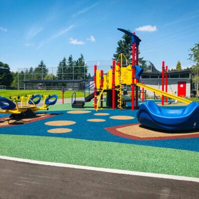 red, blue and yellow playground on pour in place rubber (PIP) surfacing