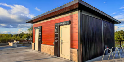 a wood clad washroom building in a park