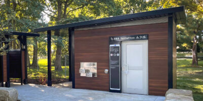 a wood clad washroom building in a park