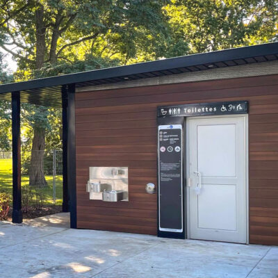 a wood clad washroom building in a park