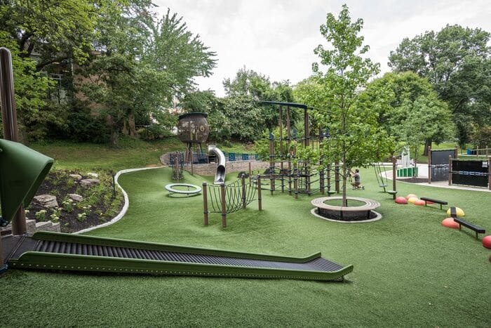 a roller slide going down a hillside covered in synthetic turf
