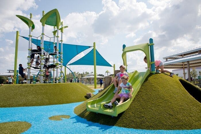 a slide on a mound covered in turf