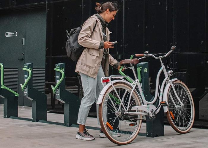 woman parking bike in a smart bike parking rack