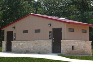 washroom building with stone lower walls, barnwood upper walls with ribbed metal roof