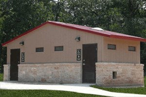 washroom building with stone lower walls, barnwood upper walls with ribbed metal roof