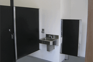 washroom building with stone lower walls, barnwood upper walls with ribbed metal roof