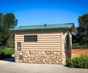 washroom bulding with barnwood siding and rocks