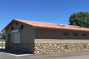 concession building with Horiztonal lap upper walls, river rock lower walls with cedar shake roof